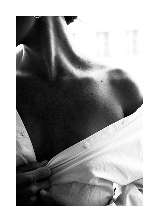 – Fotografia in bianco e nero della spalla scoperta di una donna che indossa una camicia bianca