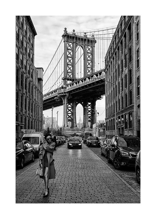 – Fotografia in bianco e nero di una donna in una strada di New York con il ponte di Manhattan sullo sfondo