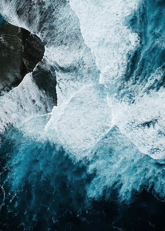 '–Onde oceaniche che colpiscono una roccia fotografata dall''alto.'