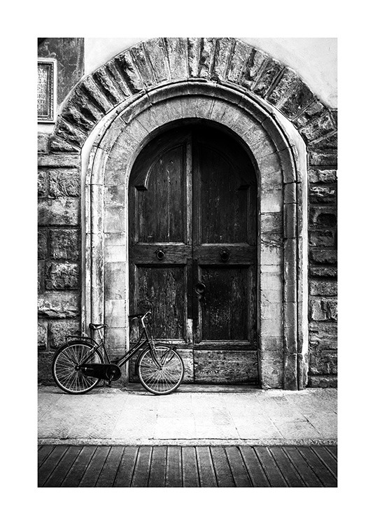  - Fotografia in bianco e nero di una porta antica con una bicicletta davanti