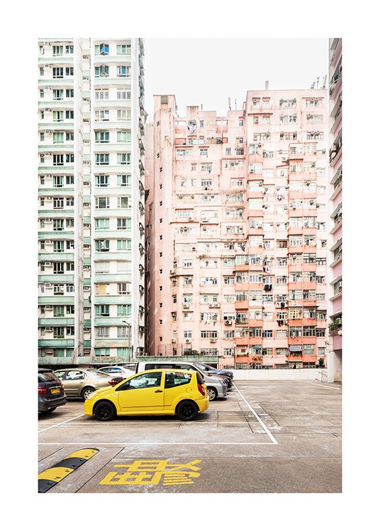  - Fotografia di un'auto gialla di fronte a edifici residenziali color verde pastello e pesca a Hong Kong