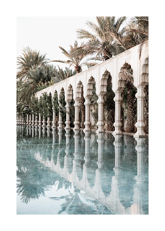  - Fotografia di colonne bianche e archi moreschi accanto a una piscina e palme sullo sfondo