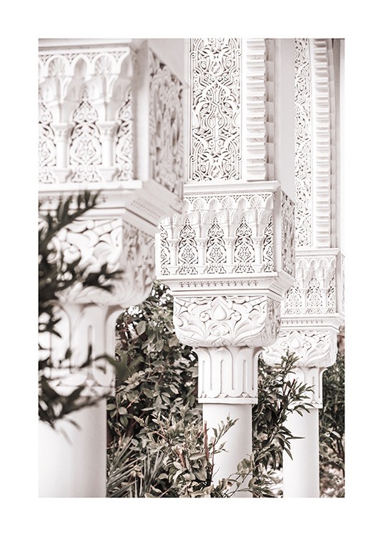  - Fotografia di colonne bianche decorate con motivi e foglie verdi sullo sfondo