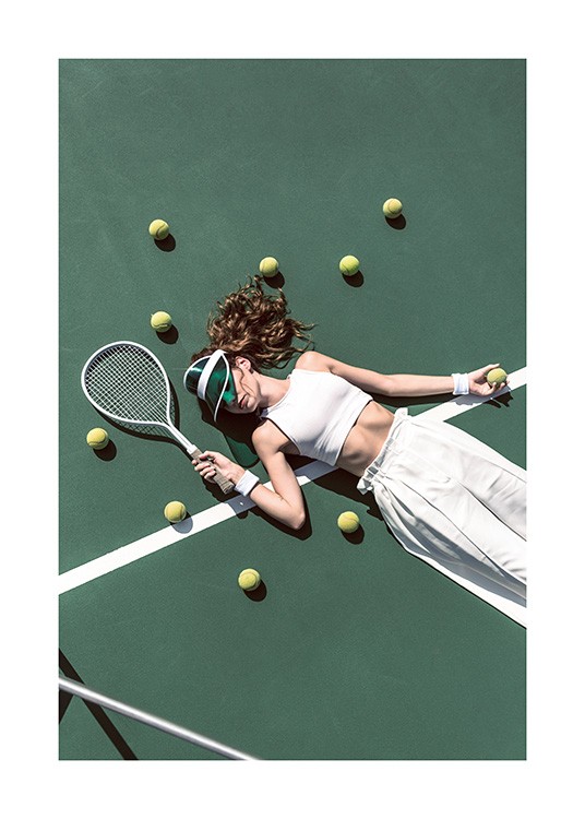  – Fotografia di una ragazza in pantaloni e top bianchi distesa su un campo da tennis e circondata da palline da tennis