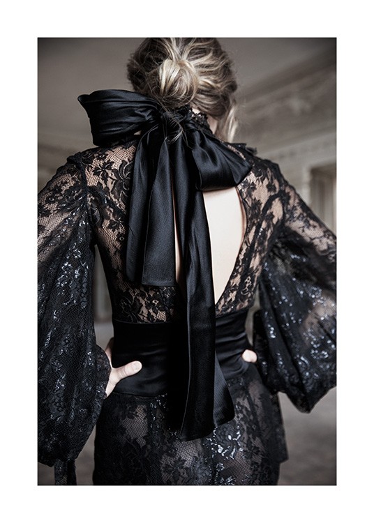  – Fotografia di una donna che indossa un abito di pizzo nero con un fiocco di raso nero al collo