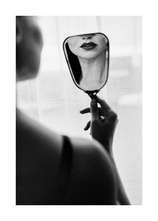  – Fotografia in bianco e nero di una donna con un rossetto scuro che si guarda in un piccolo specchio