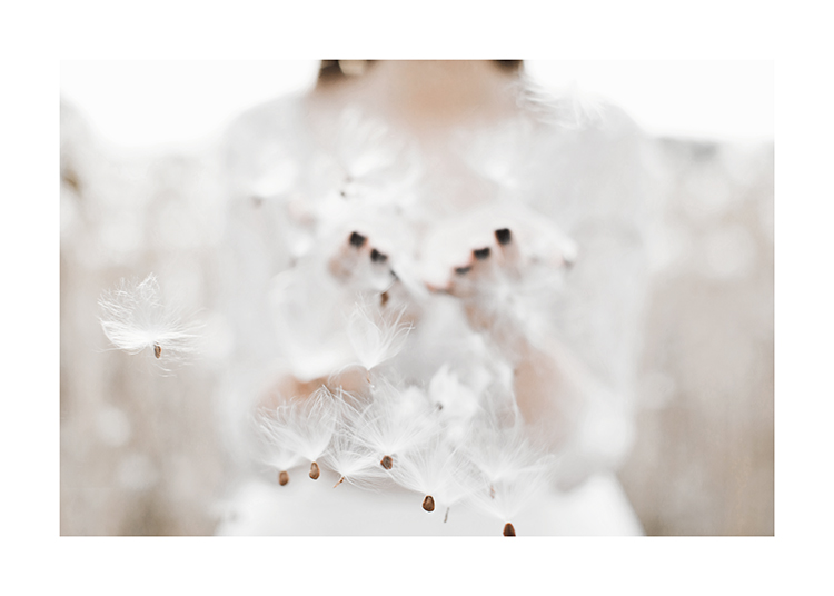  – Fotografia di semi di tarassaco al vento e una donna sullo sfondo