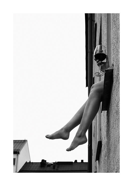  – Fotografia in bianco e nero di due gambe e una mano con un bicchiere di vino che sporgono da una finestra