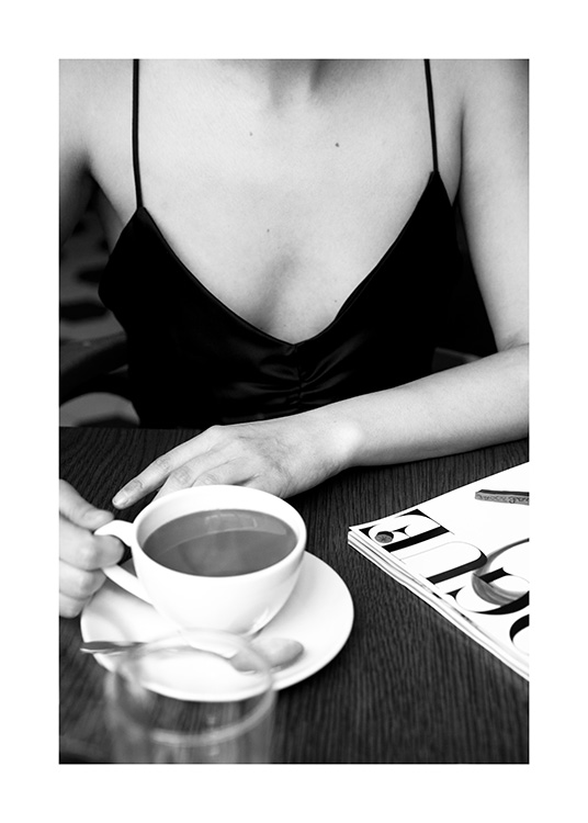  – Fotografia in bianco e nero di una donna seduta in un bar con una tazza di caffè sul tavolino